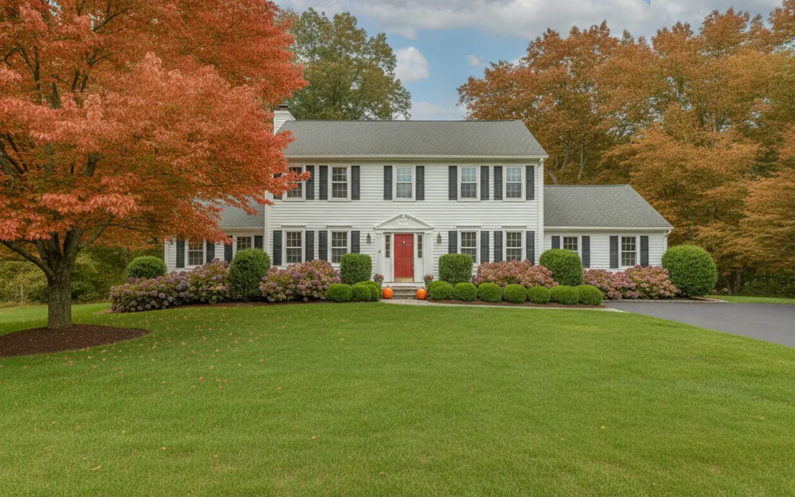 Front yard covered in orange and red maple leaves in the fall